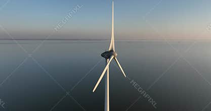 wind turbine at sunset, golden hour aerial drone view.
