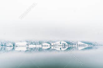The bank of the Schliersee in Bavaria in Germany lying in the wintry fog