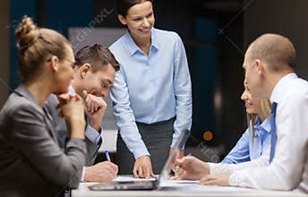 Smiling female boss talking to business team