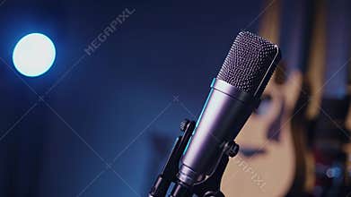 Studio microphone illuminated by blue light, ready for vocal performance or podcasting
