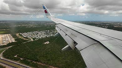 American Airlines aircraft descending over green suburbs during landing in Punta Cana with flaps extended.