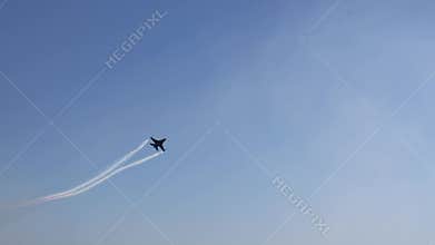 The F16 fighter performs aerobatics over the sea against the background of mountains