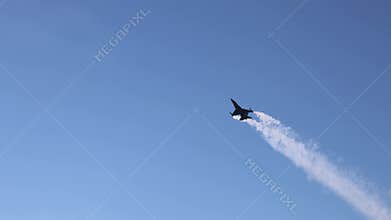 The F16 fighter performs aerobatics over the sea against the background of mountains