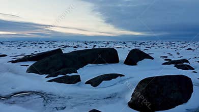 The rocky coast covered with ice and snow