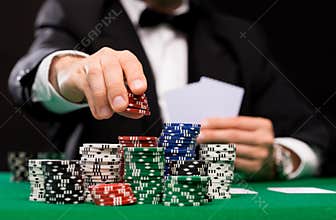 Poker player with cards and chips at casino