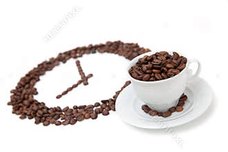 The white cup of coffee bean in front of grain clock