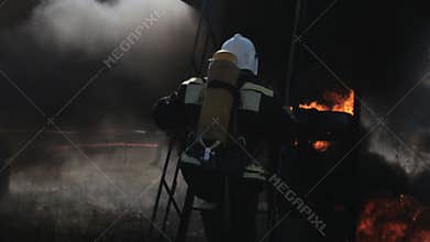 Firefighters wear uniforms near fire truck and run