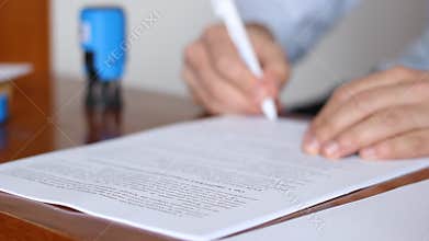 Man Signing and Stamping Documents