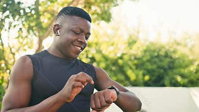 Happy African Man with Limb Difference Checks Smartwatch During Outdoor Fitness Activity