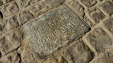 Engraved Stone Plaque of Rue Neuve Notre-Dame set in a Cobblestone Street in Paris, France