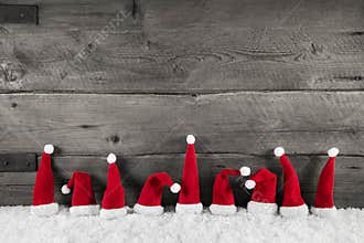 Wooden christmas background with red santa hats for a festive fr