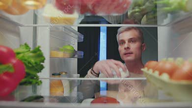 Adult Man Opening Fridge Door and Putting Fresh Healthy Food of Bag on Shelves
