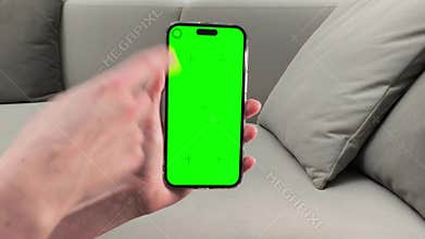 Hand holds smartphone and scrolls application on screen while sitting