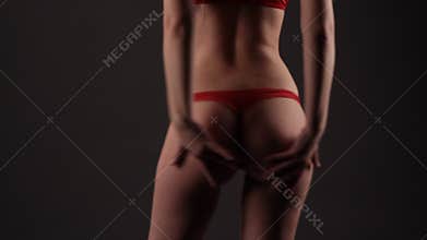 brunette woman in red lingerie dancing in the dark