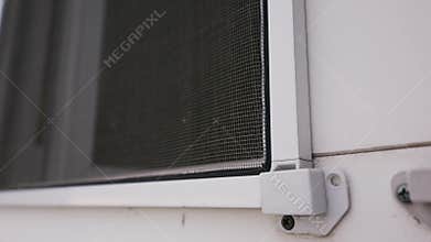 Mosquito Net Installed on White Window Frame Showing Corner Bracket