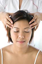 Asian female receiving gentle head massage