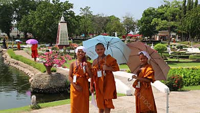 Young buddhists in yellow vestments at excursion in Mini Siam park in Pattaya, Thailand