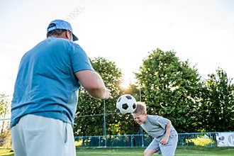 Dad and son sharing passion for football and active lifestyle.