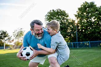 Dad and son sharing passion for football and active lifestyle.