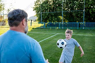 Dad and son sharing passion for football and active lifestyle.