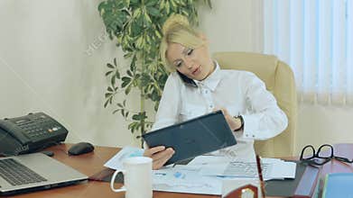 Business woman speaks by mobile phone and