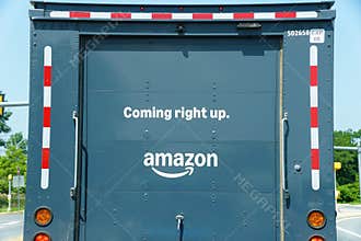 Wilmington, Delaware - July 1, 2026 - Amazon delivery truck rear with \'Coming right up\' text and signature smile logo