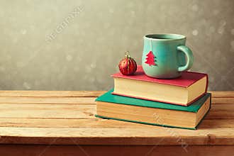 Christmas tea cup and ball on vintage books over blur background