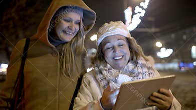 Two women walking with pad outdoor in the cold