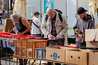 People browsing music CDs at outdoor flea market
