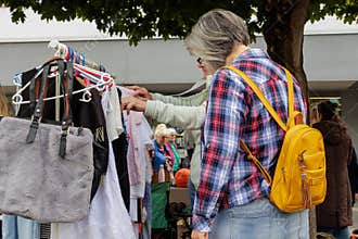 Woman browsing clothes at outdoor flea market