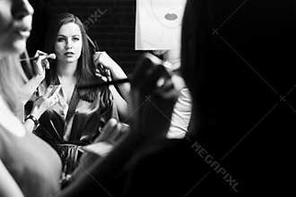 Fashion models prepared for runway by stylish designer. Black and white photography