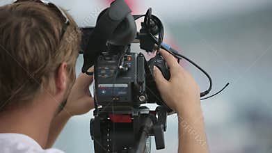 Cameraman filming scenes in the rain
