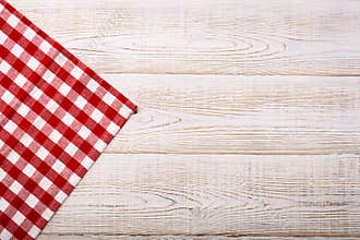 Top view of checkered tablecloth on white wooden table.