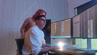 Programmers working at night analyzing code on monitors in a modern office
