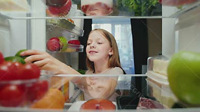 Young Happy Girl at Kitchen Opening Fridge Door and Taking Healthy Food to Eat