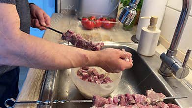 Preparing Marinated Lamb Shashlik on Metal Skewers.