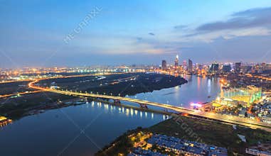Aerial night view of colorful and vibrant cityscape of downtown in Ho Chi Minh City with Thu Thiem bridge
