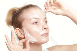 Girl woman in facial peel off mask. Skin care.