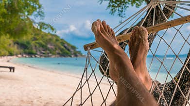 Men feet in Hammock, relaxing on the beach in Haad Rin, Ko Phangan