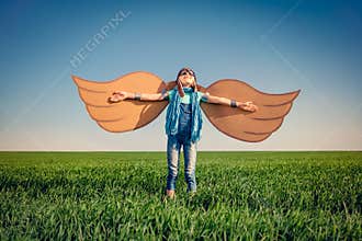 Happy child playing with toy paper wings