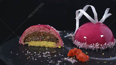 Two desserts under the icing rotate on a dark background