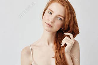 Portrait of tender beautiful girl with red hair smiling looking at camera.