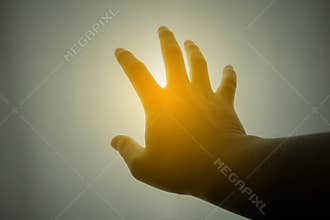 Human hand reaching for the sun