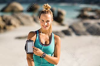 Young woman touching smartphone on armband