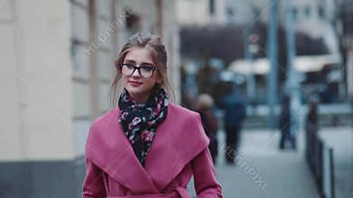 Self-confident young woman in an elegant outfit walking alone down the crowded street. Stylish look, cool haircut and