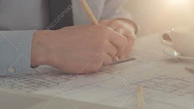 Male architect draws a construction project.