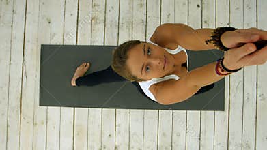 Young beautiful woman doing yoga exercise, sun salutation pose