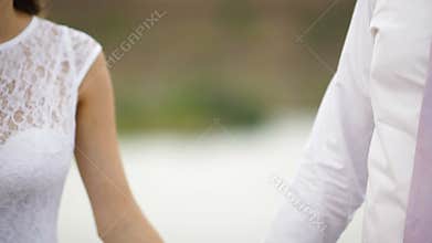 Bride and groom hold hands on a wedding walk