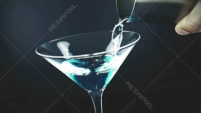 Pouring blue fresh alcohol cocktail drink glass with on blue light tint background, shot slow motion, fun and dance disco