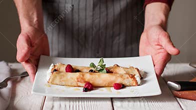 Chef is serving plate. Cottage cheese pancake roll